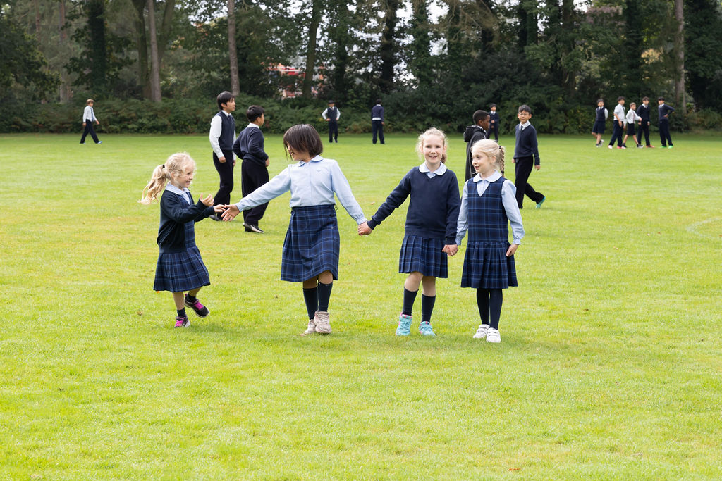 A group of Horris Hill School students walk across a grassy field